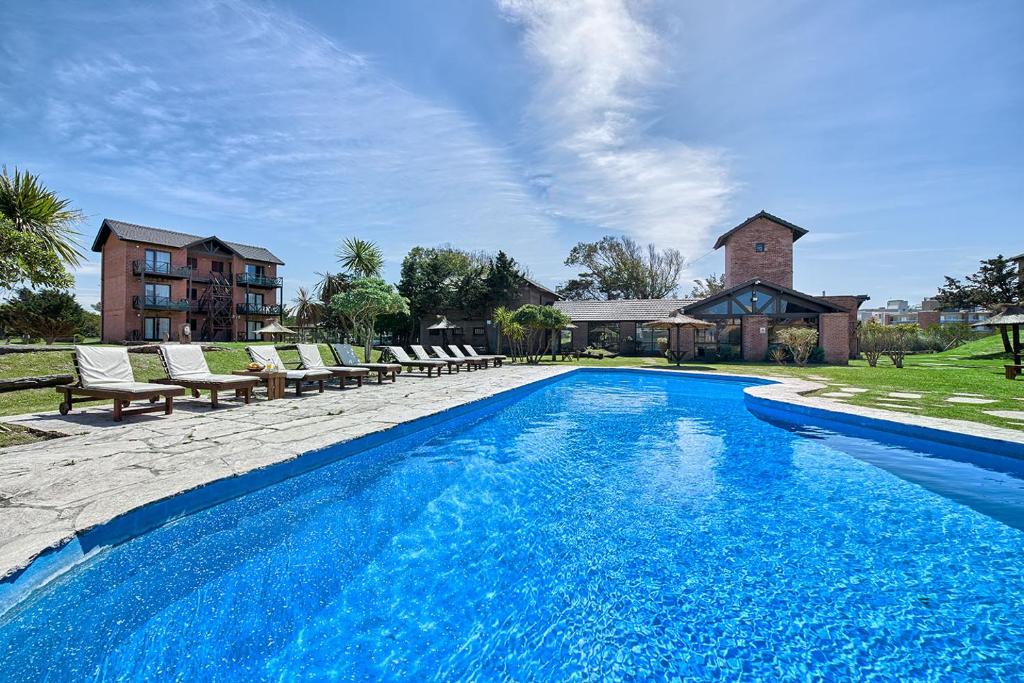 una piscina con sillas y una casa en el Marina Green Club de Villa Gesell