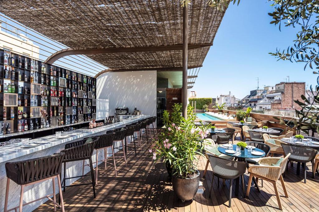 a patio area with tables, chairs, and umbrellas at Sir Victor Hotel in Barcelona