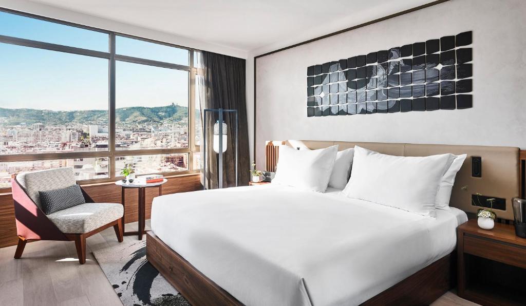 a hotel room with a large bed and a large window at Nobu Hotel Barcelona in Barcelona