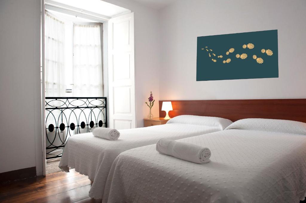una habitación de hotel con dos camas y dos luces en la Pensión Santa Cristina de Santiago de Compostela
