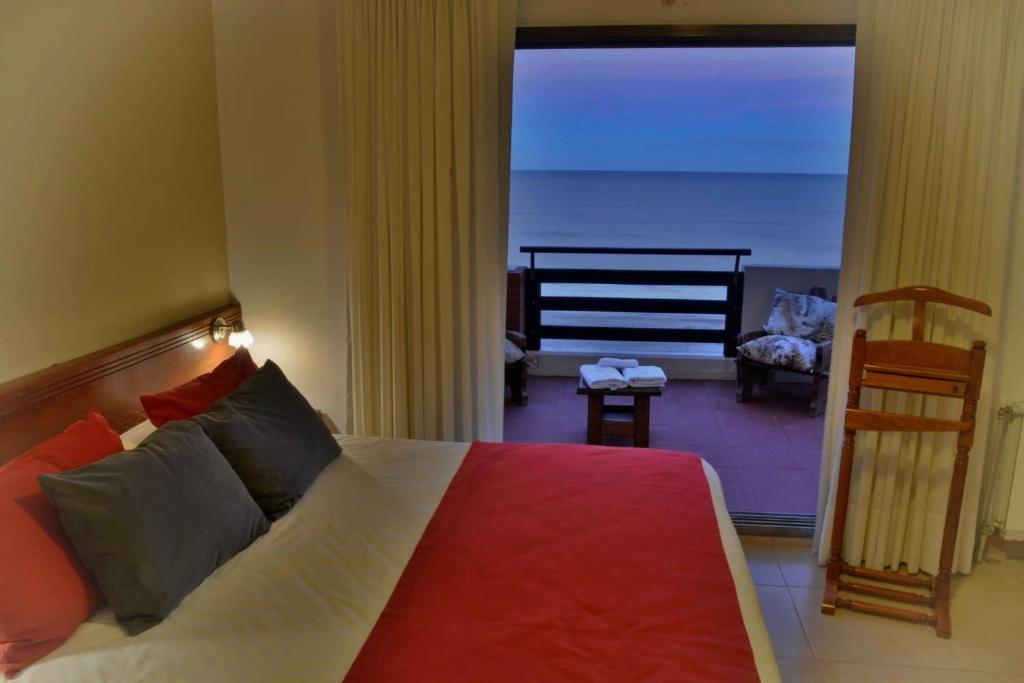 un dormitorio con una cama con vistas al océano en Intersur Villa Gesell en Villa Gesell
