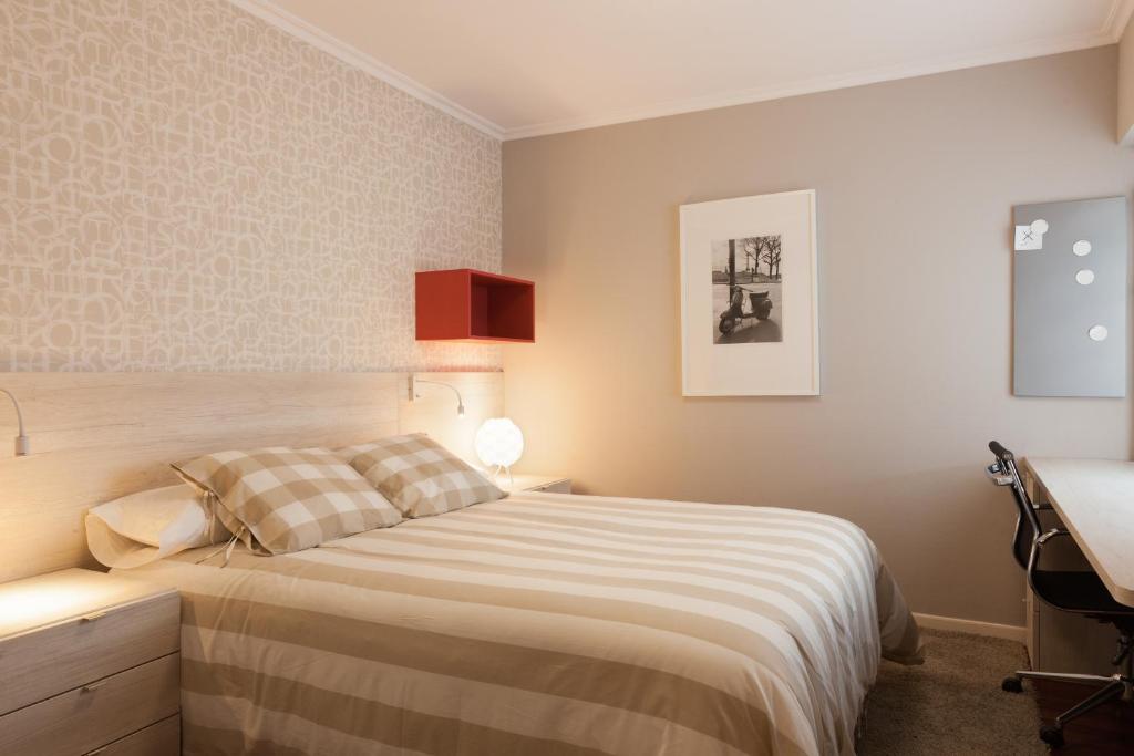 un dormitorio con cama y un escritorio en la Pension Residencia F&F de Santiago de Compostela