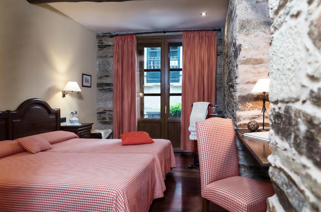 una habitación de hotel con dos camas y una mesa en el Hotel Rua Villar de Santiago de Compostela