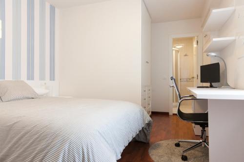 un dormitorio con cama y un escritorio y un ordenador en la Pension Residencia F&F de Santiago de Compostela