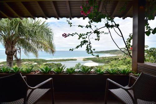 a patio area with a view of the water at Villa Gardena Suites in Praia do Rosa