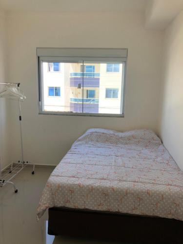 a bedroom with a bed and a window at Apartamento ingleses in Florianópolis