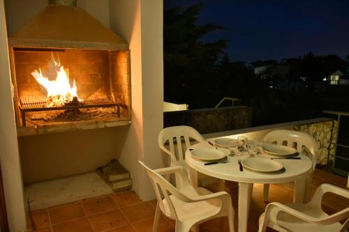 una mesa y sillas con chimenea en un patio en Cabañas Cambados en Villa Gesell