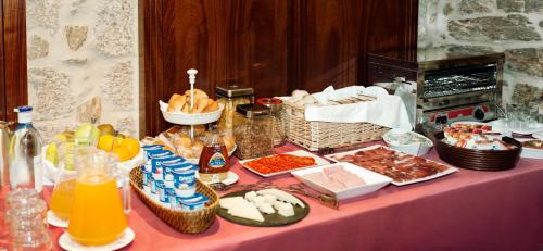 una mesa cubierta con platos de comida y bebidas en el Hotel Rua Villar de Santiago de Compostela