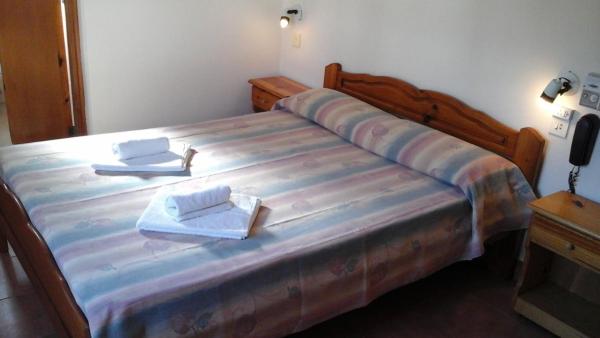 una habitación con una cama grande con dos toallas en el Hotel Mariska Dos Estrellas Superior de Villa Gesell