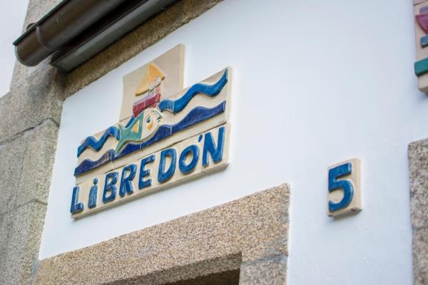 un letrero en el lateral de un edificio de Libredón Rooms en Santiago de Compostela