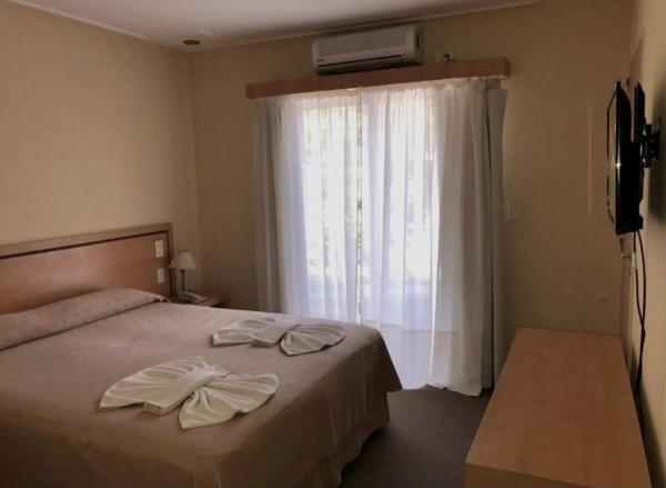 un dormitorio con cama con dos toallas en el Hotel Vesubio II de Villa Gesell
