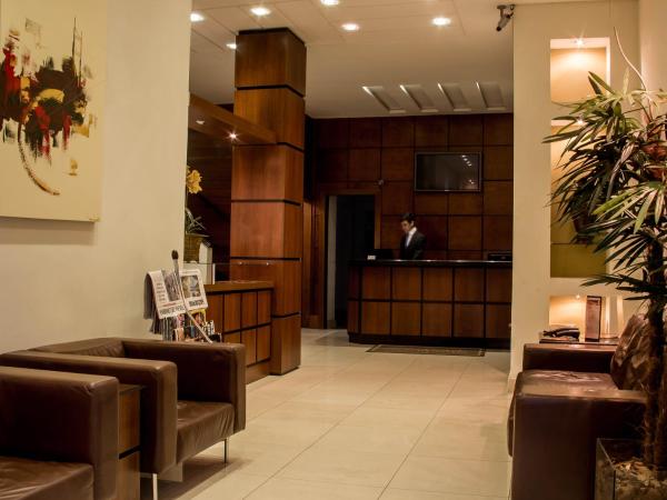 a living room filled with furniture and a large window at Hotel Brasilia Curitiba in Curitiba