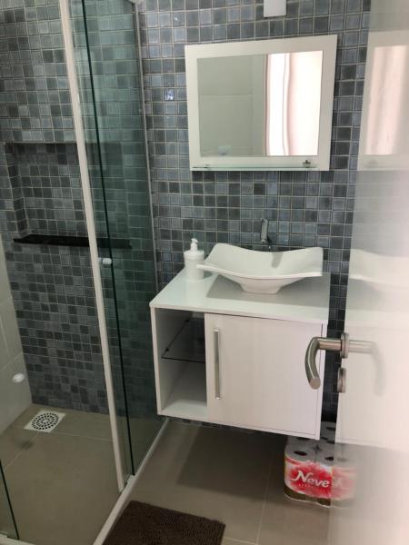 a bathroom with a sink and a mirror and a shower at Apartamento ingleses in Florianópolis
