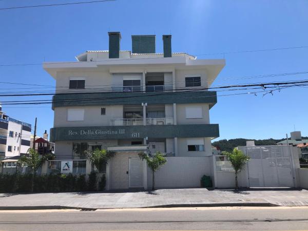 a large white building on the side of a street at Apartamento ingleses in Florianópolis