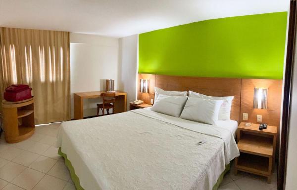 Cama o camas de una habitación en Confortável suíte com vista para praia por Carpediem