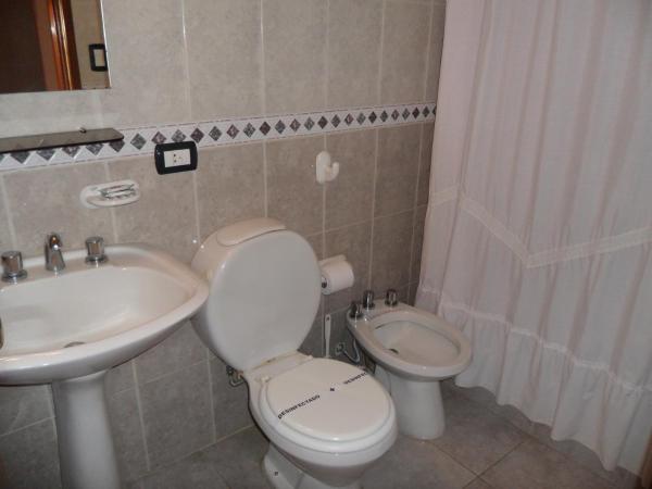 un lavabo blanco sentado junto a un fregadero en un baño del Hotel de Cine Las Golondrinas de Villa Gesell