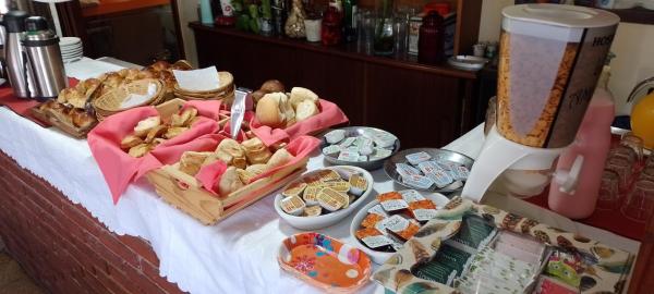 una mesa cubierta con muchos tipos de comidas diferentes en la Hostería Los Amigos de Villa Gesell
