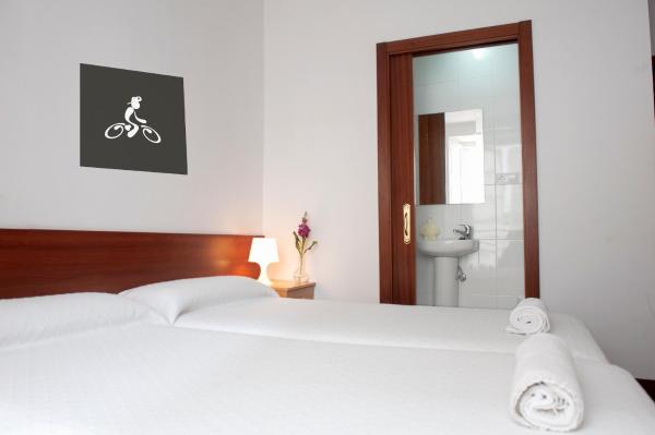 una habitación de hotel con una cama blanca y paredes blancas en la Pensión Santa Cristina de Santiago de Compostela
