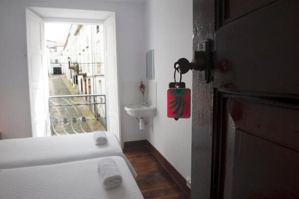 un baño con una puerta blanca y un aseo blanco en la Pensión Santa Cristina de Santiago de Compostela