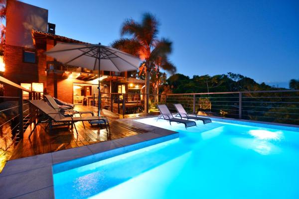 a pool with a pool table and a balcony at Villa Gardena Suites in Praia do Rosa